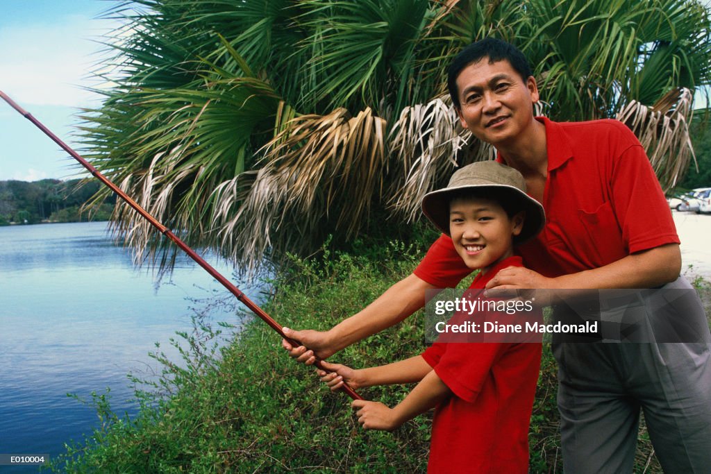 Dad teaching daughter how to fish