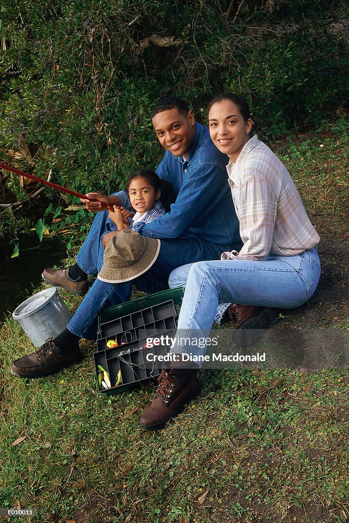 Smiling family of three fishing together