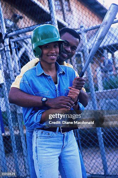 african american couple in batting cage holding baseball bat - baseball cage stock pictures, royalty-free photos & images