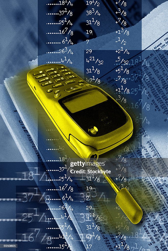 Yellow cellular phone with stock quotes behind