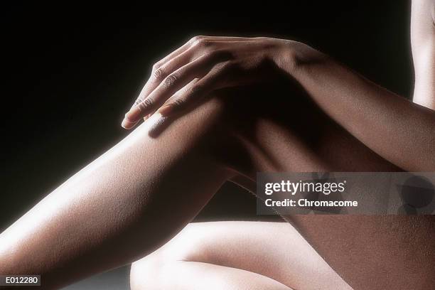 female hand on knee - human knee stock pictures, royalty-free photos & images