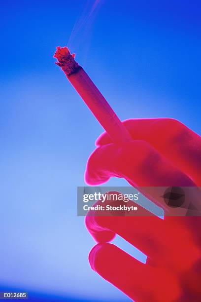 hand holding cigarette - colour enhanced stock pictures, royalty-free photos & images