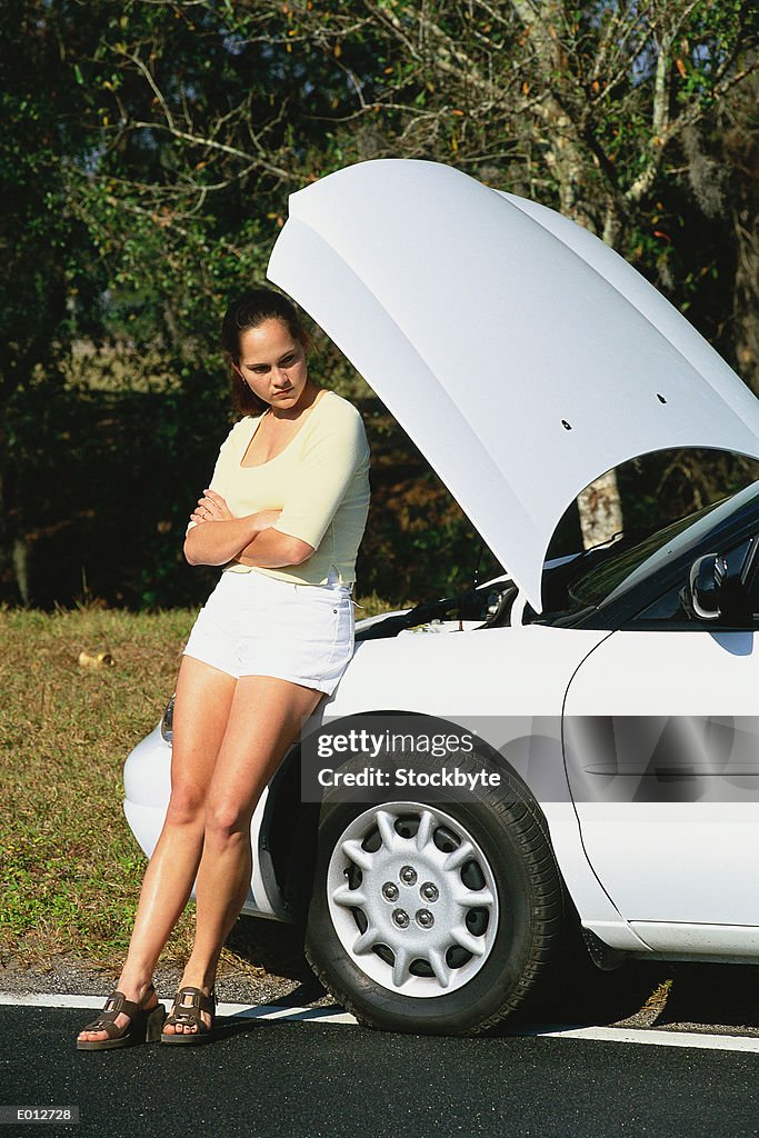 Woman leaning on stranded car
