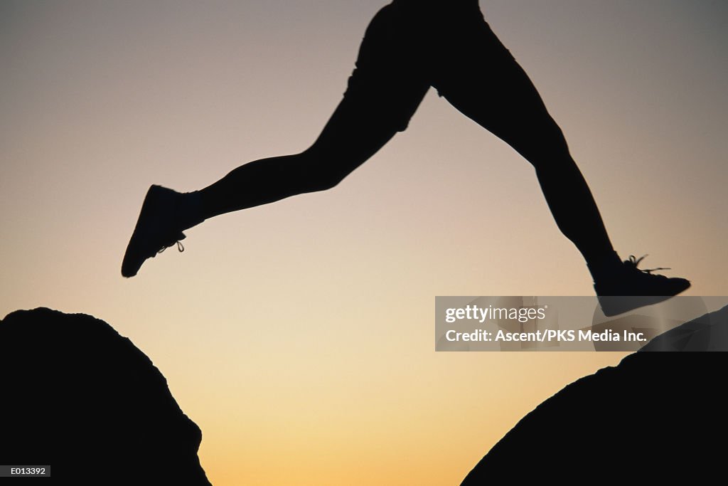 Silhouetted legs, mid-jump