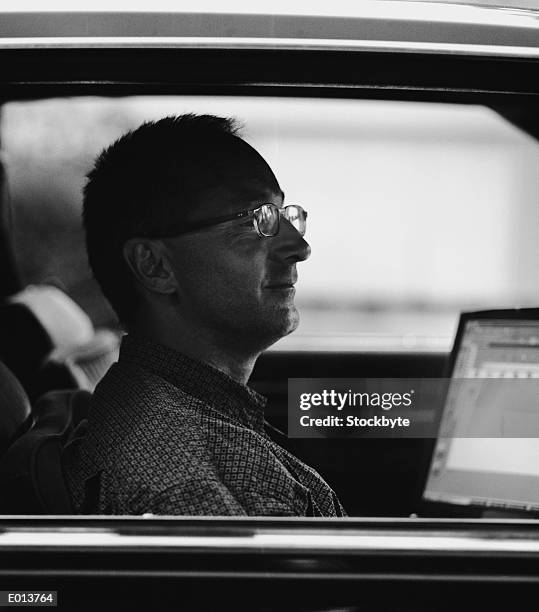 man in car with open laptop - candid black and white corporate stock pictures, royalty-free photos & images