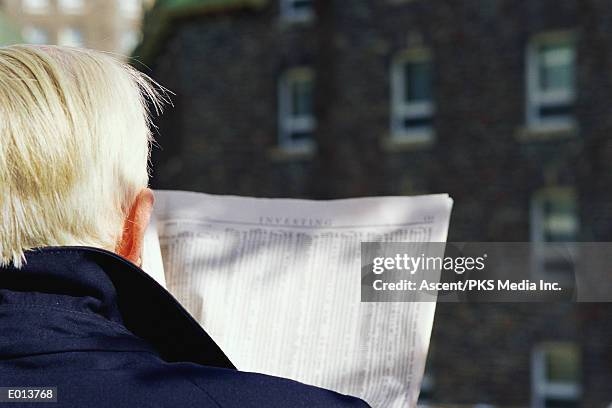 man checking stock listings in newspaper - broadsheet stock pictures, royalty-free photos & images