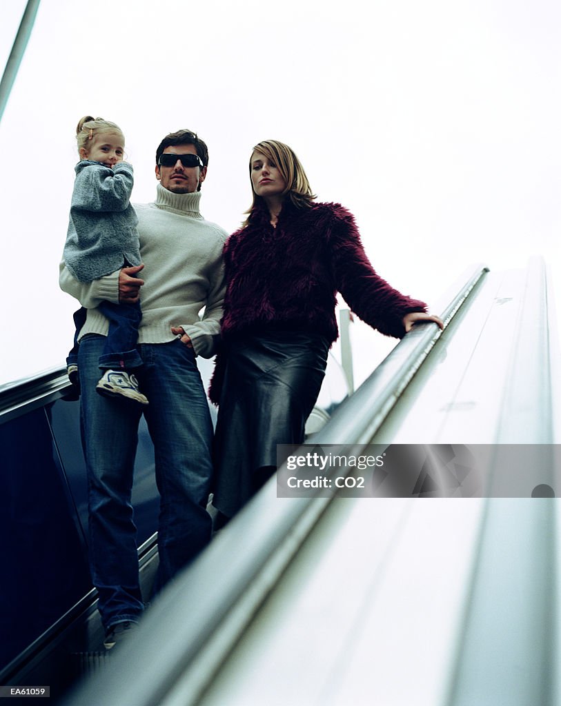 Family of three on escalator
