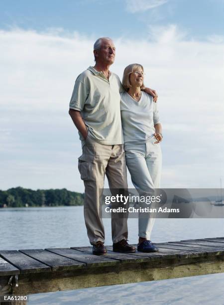 mature couple standing on jetty with arms around each other - ammersee stock pictures, royalty-free photos & images