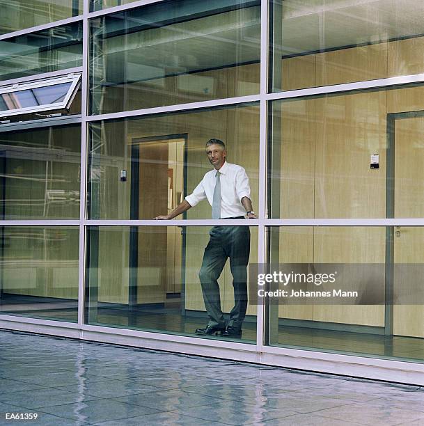 businessman looking out window - mann stock pictures, royalty-free photos & images