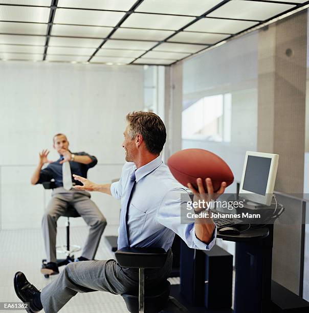 businessman throwing ball to colleague - business mann laptop stock pictures, royalty-free photos & images