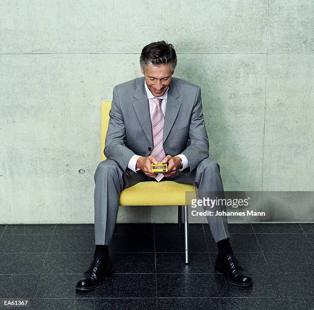 businessman playing electronic game - mann stock pictures, royalty-free photos & images