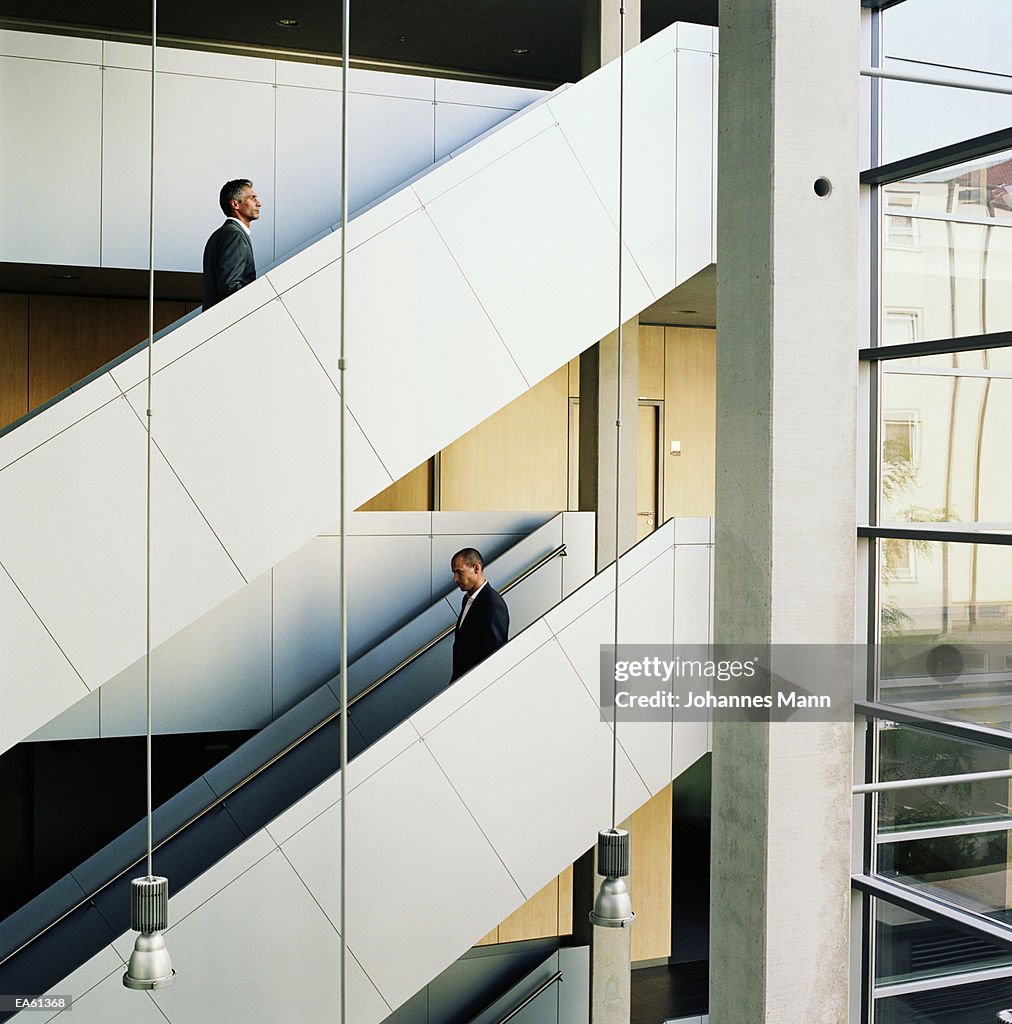 Businessmen walking up and down staircase
