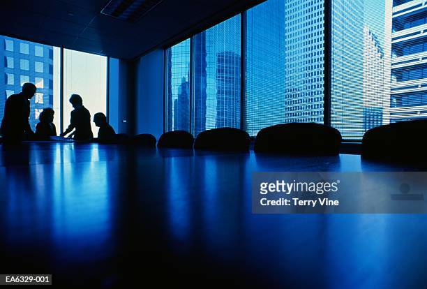 executives at end of conference table, silhouette - boardroom stockfoto's en -beelden
