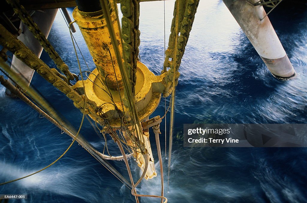 Oil rig drilling pipe at surface of water