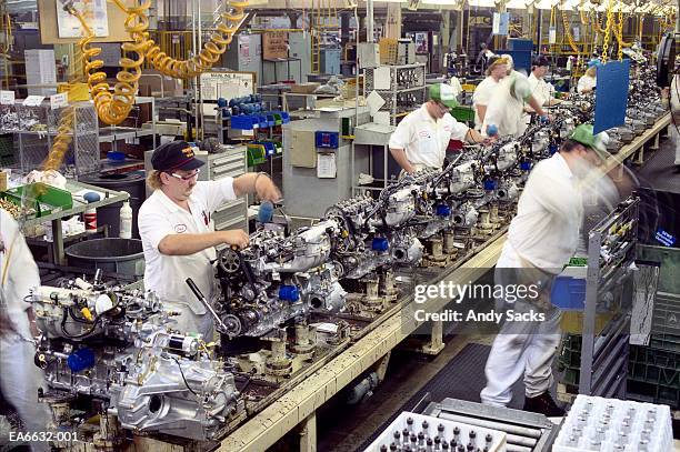 factory workers building engines on assembly line, usa (blurred motion - production line imagens e fotografias de stock
