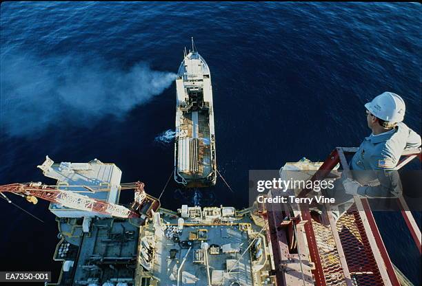 supply barge beside offshore oil rig, worker on platform, elevated - oil worker stock pictures, royalty-free photos & images