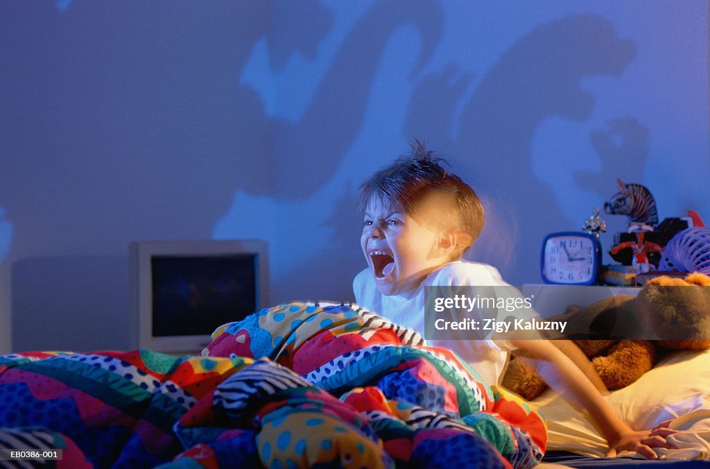 Boy (5-7) screaming at shadows of monsters on wall