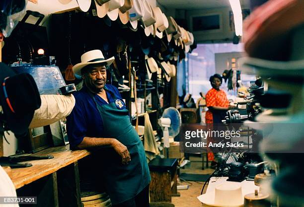 hat maker in his shop, wife in background, tennessee, usa - nashville stockfoto's en -beelden