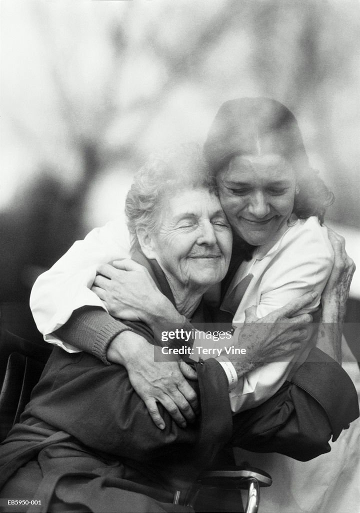 Nurse hugging elderly patient in wheelchair (B&W)