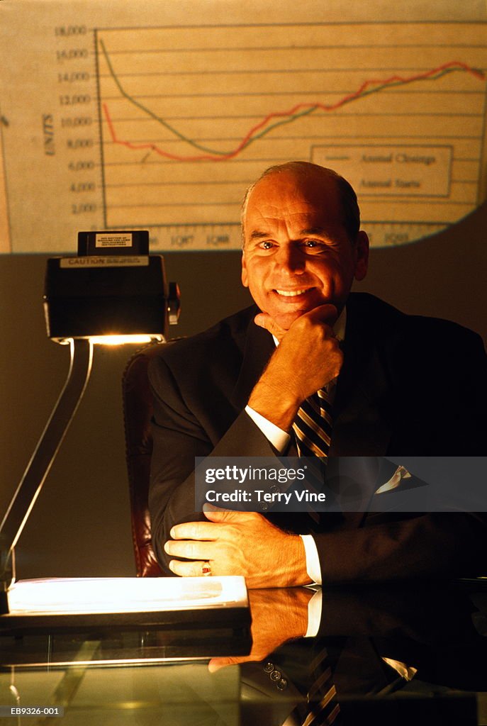 Mature executive with overhead projector, portrait