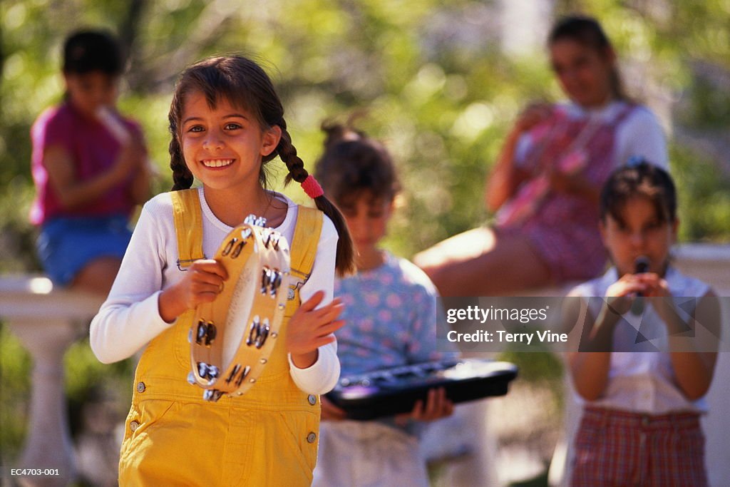 Group of girls (6-9) playing music in park