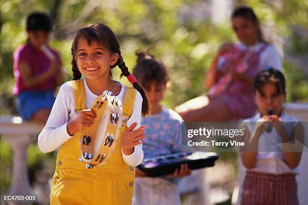 group of girls (6-9) playing music in park - tambourine stock pictures, royalty-free photos & images