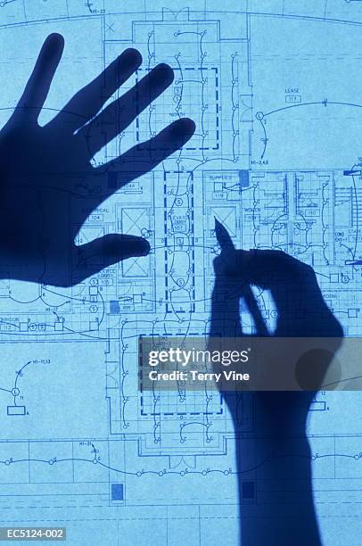 silhouette of hands on architectural drawing - blauwdruk stockfoto's en -beelden