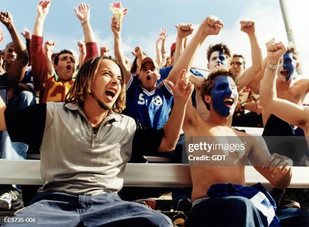stadium crowd cheering, fans with faces painted in white and blue - tribüne stock-fotos und bilder