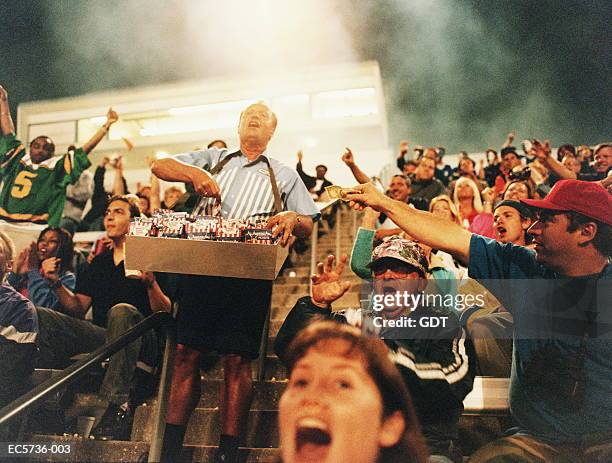 peanut vendor selling in stadium, man holding out money - peanut food stock pictures, royalty-free photos & images