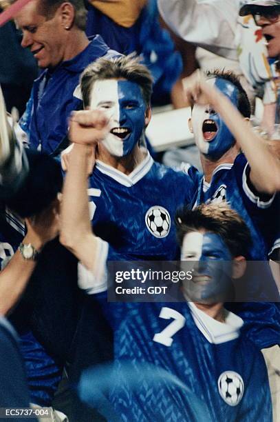 soccer fans with painted faces in stadium - man face paint stock pictures, royalty-free photos & images