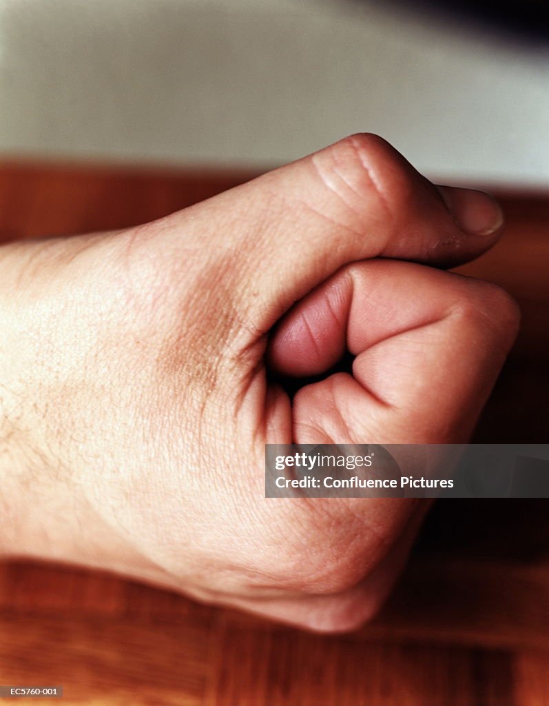 Man's hand making fist, side view, close-up