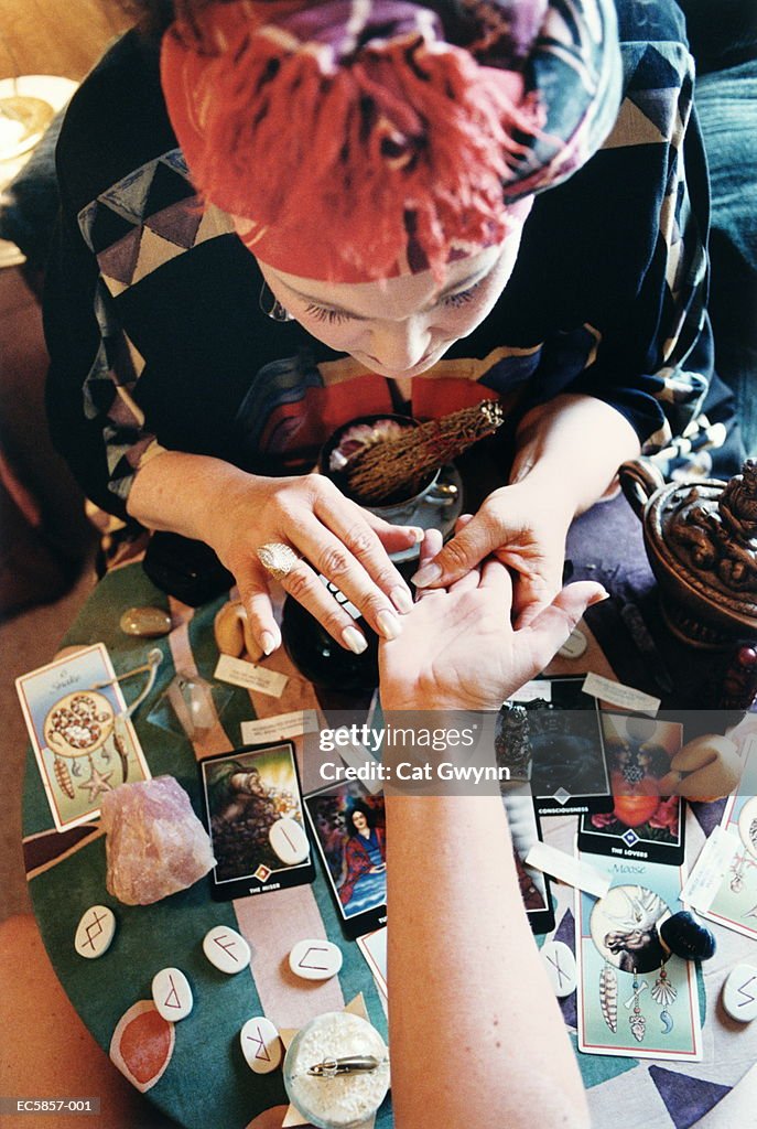 Fortune teller reading palm, overhead view