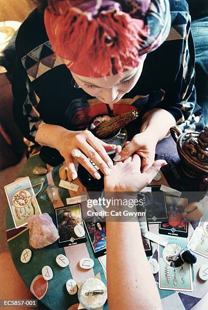 fortune teller reading palm, overhead view - adivino fotografías e imágenes de stock