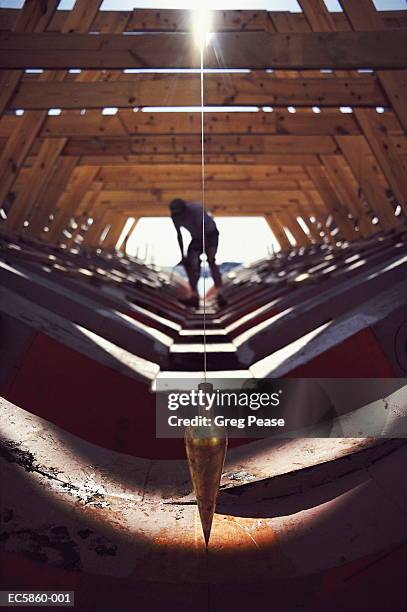 wooden boat under construction, plumb bob in foreground - shipyard stock-fotos und bilder