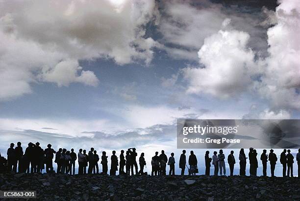 group of people in queue on cliff - people in a row stock pictures, royalty-free photos & images