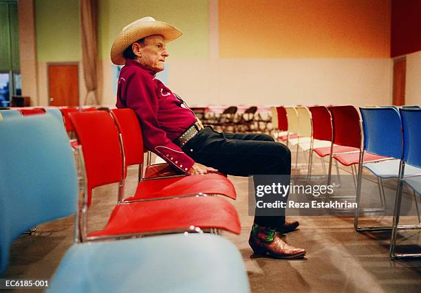 elderly man wearing cowboy hat, sitting in auditorium chair - country music stock pictures, royalty-free photos & images