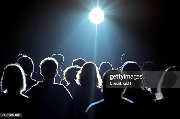 crowd of people looking at bright light, rear view - group in silhouette stock pictures, royalty-free photos & images