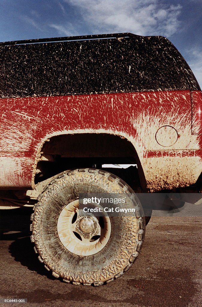 Sports utility vehicle with mud splattered body and wheel