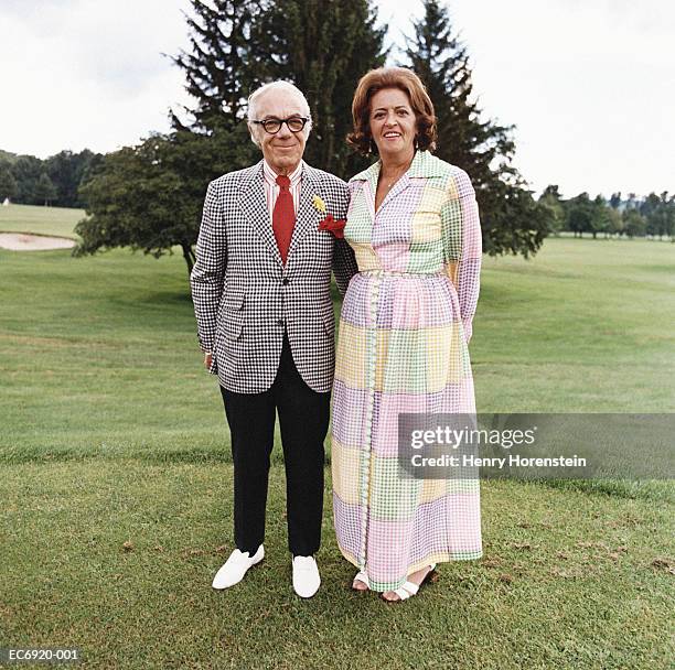 mature couple in formal attire standing on golf course - checked dress stock pictures, royalty-free photos & images