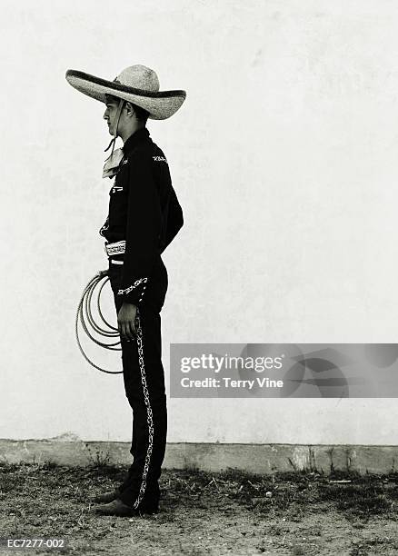 mexican cowboy wearing hat and holding lasso, profile (toned b&w) - sombrero stock pictures, royalty-free photos & images