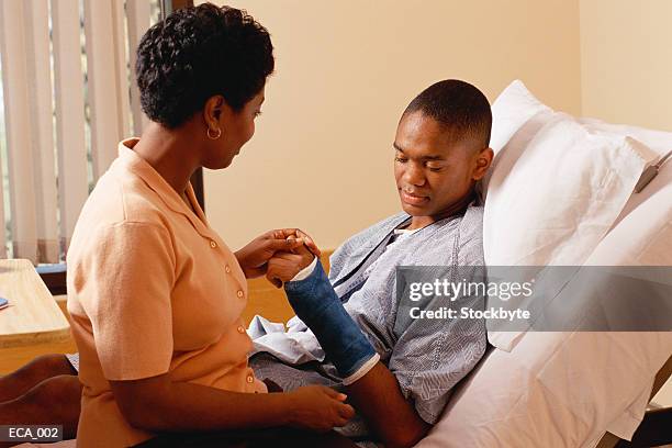 woman sitting on son's hospital bed - broken arm stock pictures, royalty-free photos & images