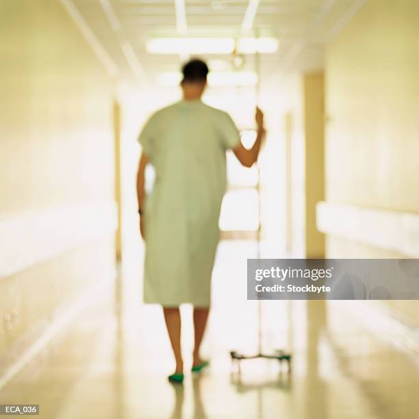 person walking in hallway with iv stand, blurred shot - hemodialisis fotografías e imágenes de stock