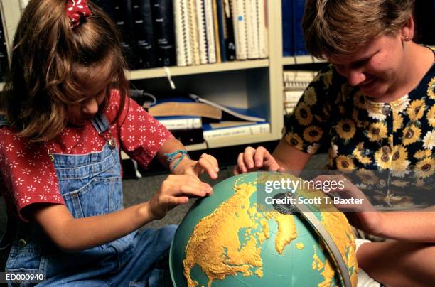 blind girls with globe - schreibtischspielzeug stock-fotos und bilder