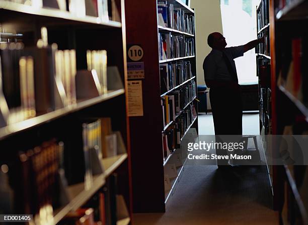 man searching for book at library - searching for something ストックフォトと画像