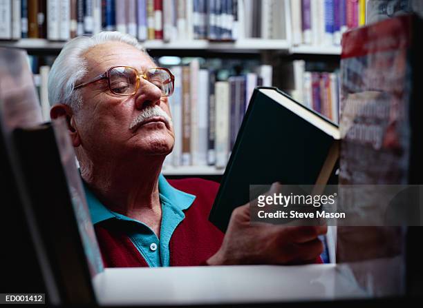 man searching for book at library - searching for something ストックフォトと画像