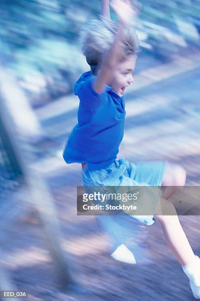 blurred shot of boy jumping from jungle gym - jungle gym stockfoto's en -beelden