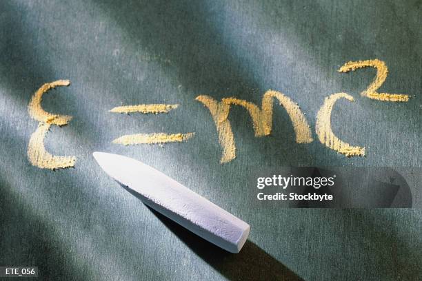 chalkboard with e=mc2 written on it, chalk resting on top - e=mc2 stock-fotos und bilder