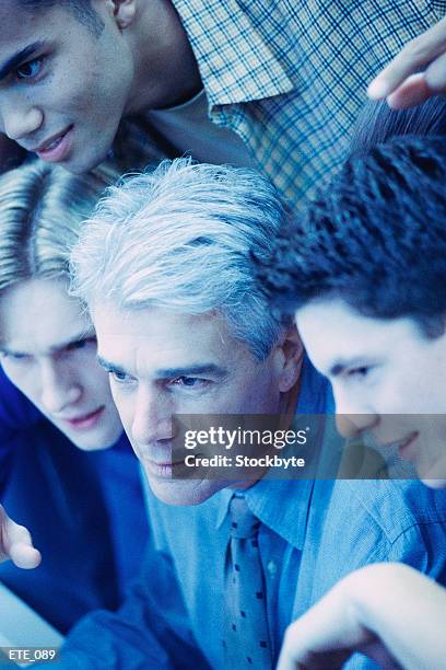 students gathered around teacher, all looking in same direction - all stock pictures, royalty-free photos & images