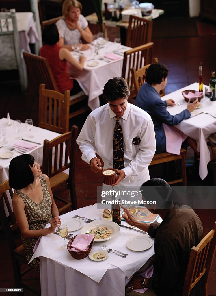 Waiter serving patrons in restaurant, elevated view