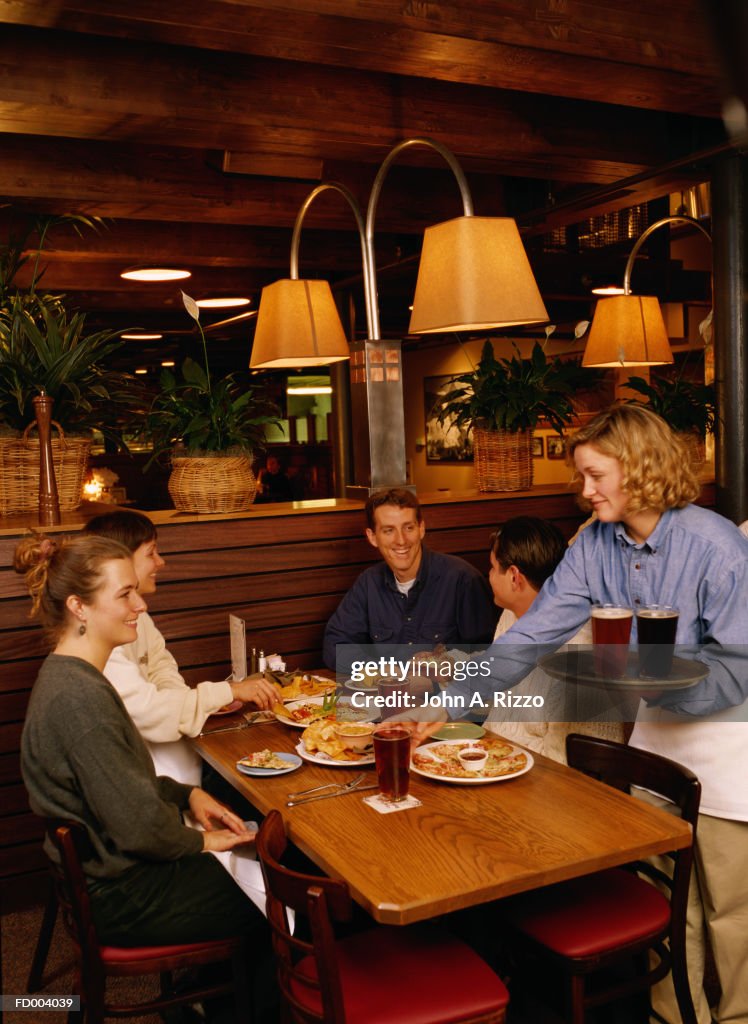 Waitress serving beer to guests
